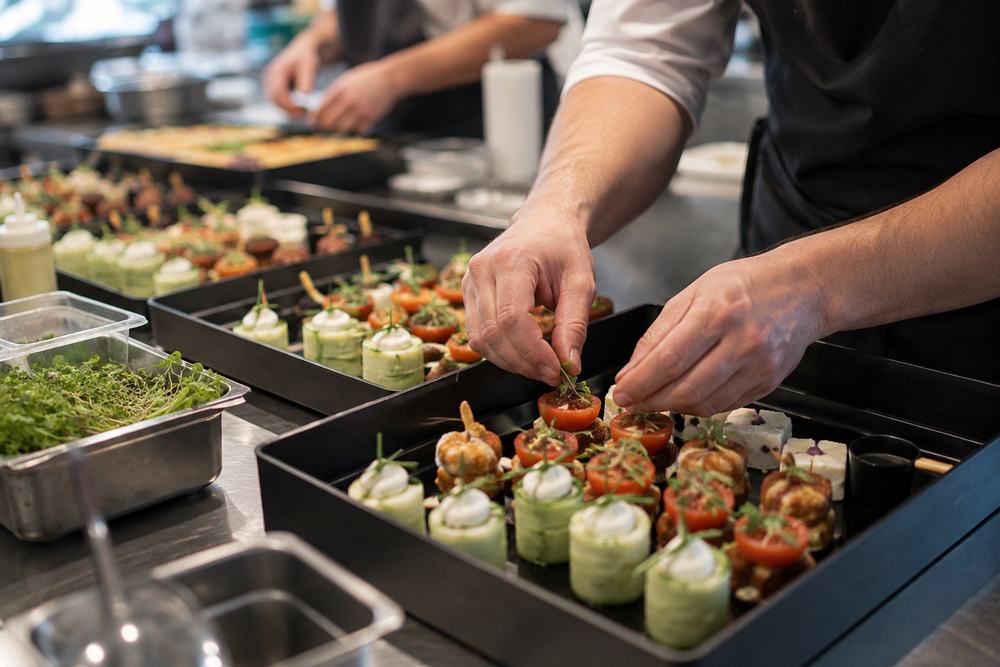 Deux cuisiniers dressent des pièces cocktail en bacs, en cuisine
